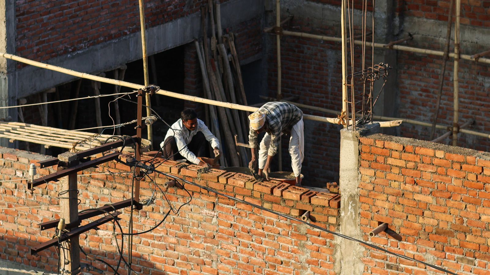 Tradespeople building a wall on site