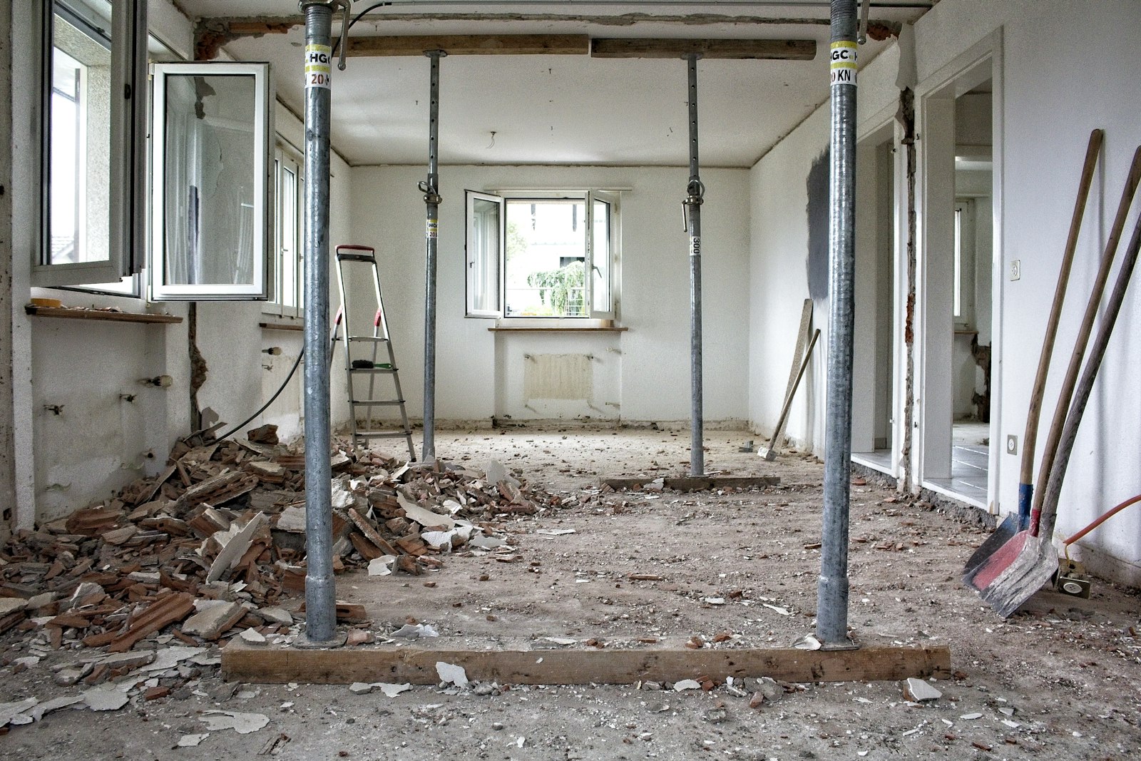 The interior of a home mid-renovation, braced with structural shoring posts