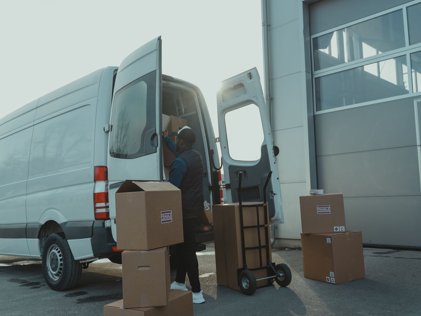 A courier loading parcels into a van