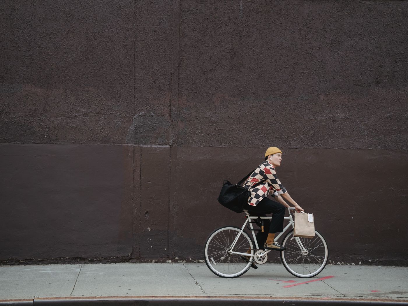 A bike messenger riding through the city with a courier bag