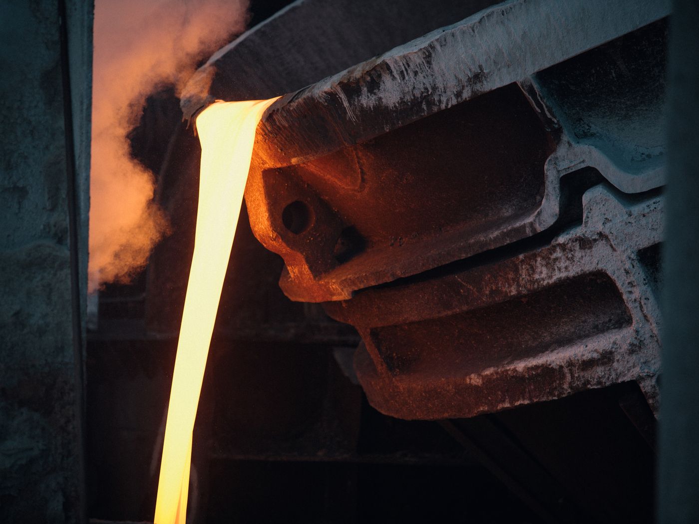 Molten metal pouring from a ladle in a foundry