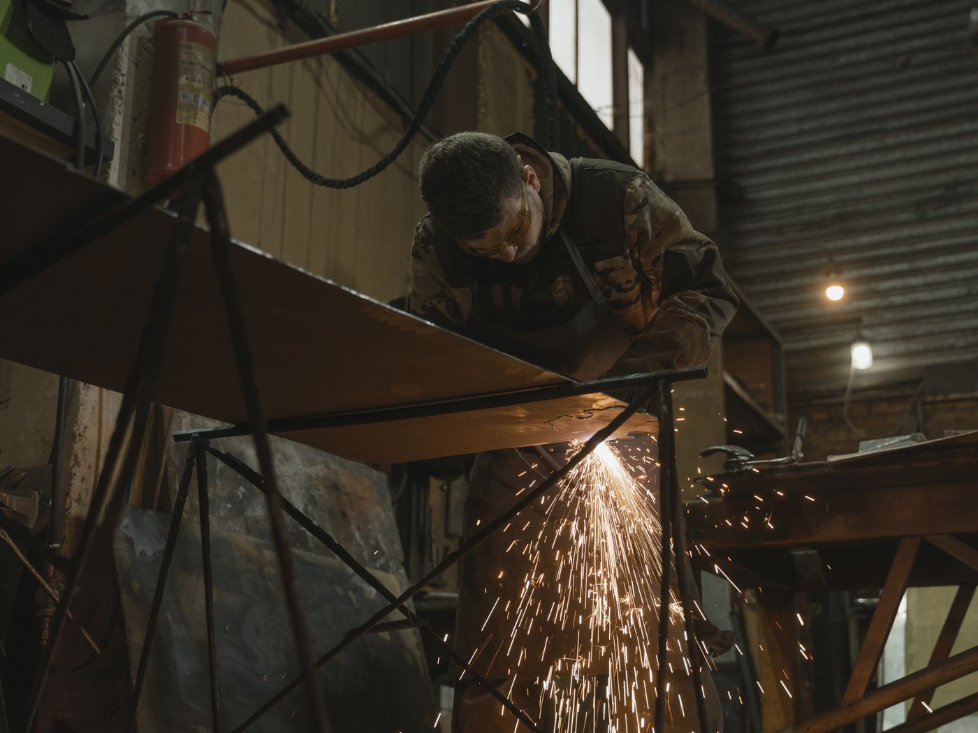A welder cutting steel plate in a fab shop
