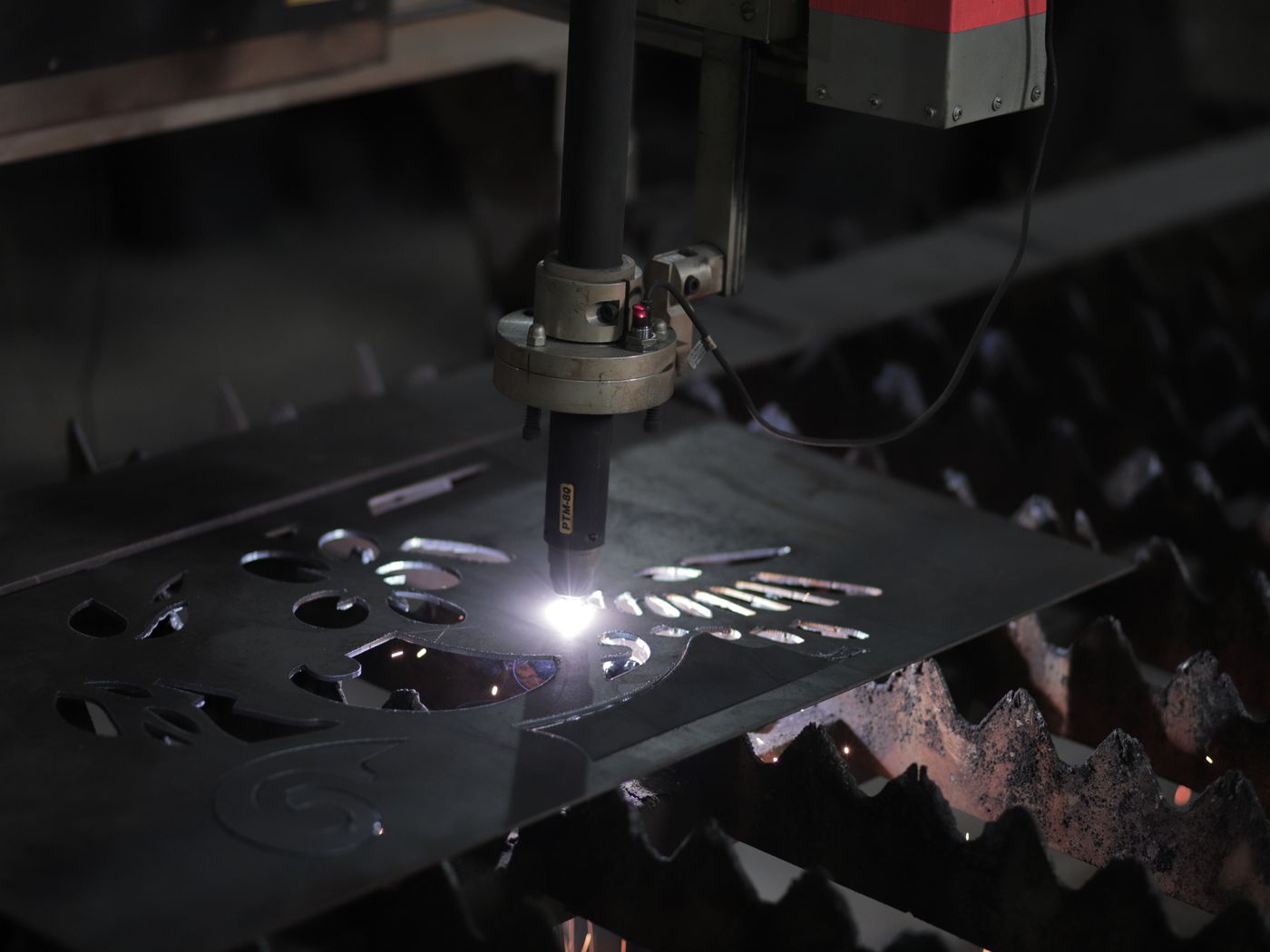 A plasma cutter working a flat sheet of steel