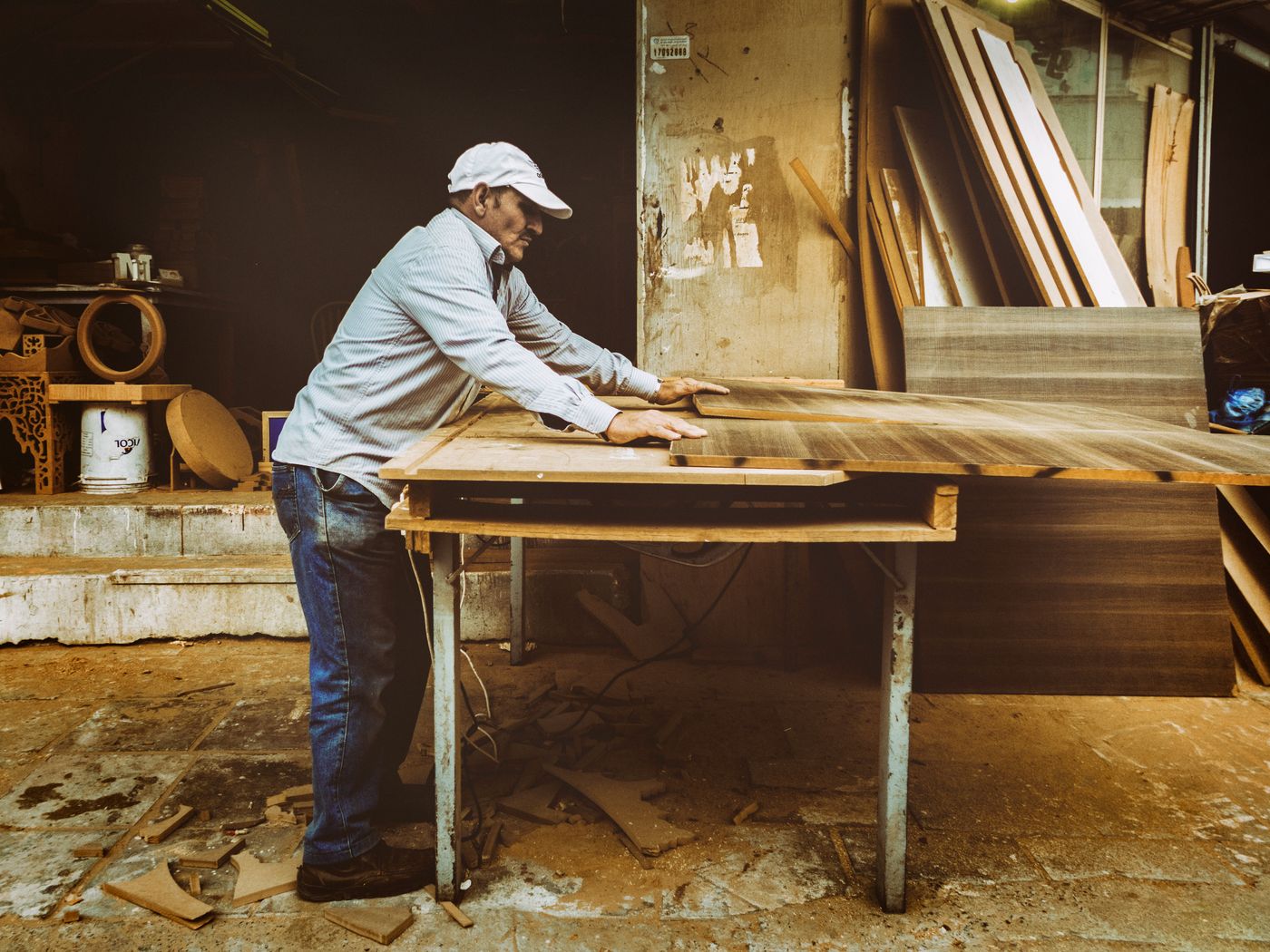 A carpenter working a panel at the bench in a wood shop